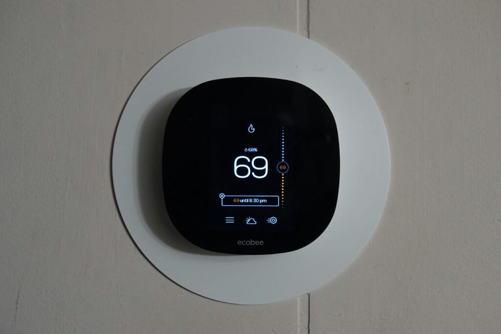 This image depicts a smart thermostat system mounted to a wall.
